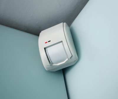 burglar alarm movement sensor mounted on a wall